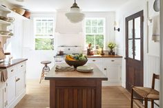 a kitchen with white cabinets and wooden counter tops next to a breakfast nook area