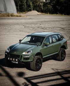 a green suv parked in an empty parking lot