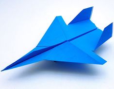 a blue origami bird sitting on top of a white table