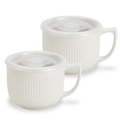 two white coffee mugs sitting next to each other on a white surface with the lids off