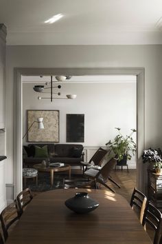 a dining room table with chairs and a computer mouse on top of it in front of a couch