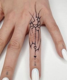 a woman's hand with a tattoo design on the middle finger and an arrow in the middle