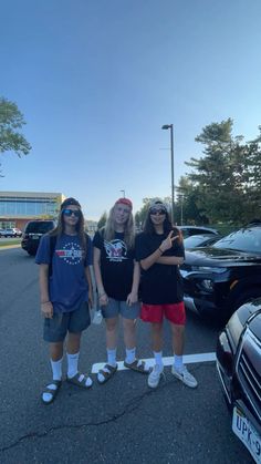 three girls are standing in the parking lot