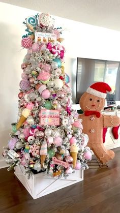 a decorated christmas tree in the living room with a teddy bear and other ornaments on it