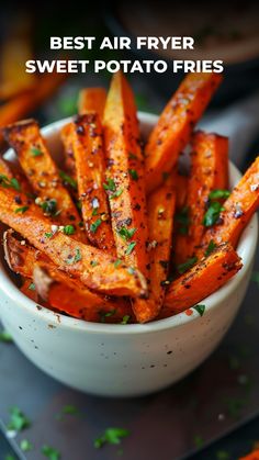 the best air fryer sweet potato fries in a white bowl with parsley on top