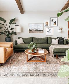 a living room with green couches and pictures on the wall above them, along with a coffee table