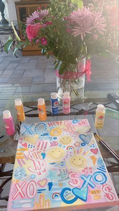 a table with flowers and candles on it in front of a vase full of flowers