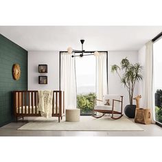 a baby's room with green walls and white carpet, rocking chair, crib, potted plant and window