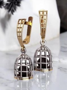 Discover the elegance of these 925 silver cage earrings, featuring a sophisticated gold birdcage design and stunning caged black pearls. These handcrafted earrings combine high-quality sterling silver and gold to create a unique and luxurious piece of jewelry. The intricate birdcage design captures a delicate black pearl, adding a touch of mystery and sophistication to your look. Perfect for those who appreciate unique and elegant jewelry, these earrings are ideal for both everyday wear and spec Black Pearl Earrings, Handcrafted Earrings, Black Pearl, Bird Cage, Elegant Jewelry, Solid 925 Sterling Silver, Silver Gold, 925 Silver, Silver Earrings