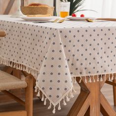 a table with a white and blue polka dot design on it, next to a bowl of fruit