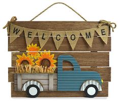 a wooden sign that says welcome with sunflowers and a truck on the front