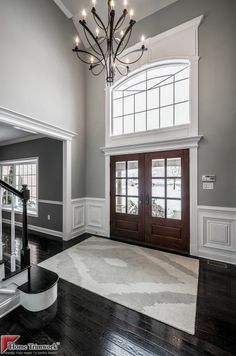 an empty room with a chandelier hanging from the ceiling