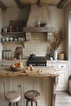 an old fashioned kitchen with two stools in front of the stove and counter top