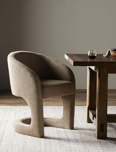 a chair sitting on top of a rug next to a table with a cup in it