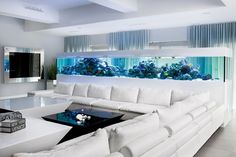 a living room filled with white furniture and an aquarium