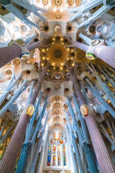 the inside of a cathedral with many columns and stained glass windows on each side, looking up at the ceiling