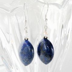 The fall season brings out our natural inclination to be fashionistas. These dark blue lapis lazuli gemstone earrings with pyrite sparkles are trendy, dangly and easy to wear with everything in your closet. Reminds me of the celestial night sky. Handmade with sterling silver earring closures. Great gift for women born in September since lapis lazuli is one of her birthstones.Earring Details:- Earrings are 1.75 inches (4.45 cm) long- Lapis lazuli gemstones are .75 inches tall and .5 inches wide ( Elegant Sapphire Earrings With Natural Stones, Blue Lapis Lazuli Teardrop Earrings, Blue Teardrop Lapis Lazuli Earrings, Blue Lapis Lazuli Teardrop Jewelry, Blue Teardrop Lapis Lazuli Jewelry, Elegant Lapis Lazuli Earrings With Natural Stones, Blue Lapis Lazuli Oval Jewelry, Elegant Lapis Lazuli Gemstone Earrings, Sapphire Teardrop Lapis Lazuli Jewelry