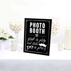 a table topped with lots of white candies next to a sign that says photo booth