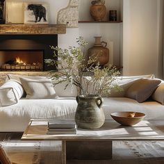 a living room filled with furniture and a fire place next to a couch in front of a fireplace