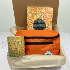 an orange travel bag and coffee mug sitting in front of a map with the words national park on it