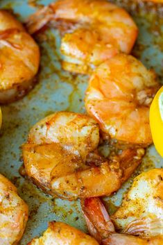 some shrimp and lemons are on a pan