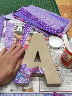 a person is making a letter out of scraps and paper with glue on the table