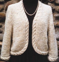 a woman wearing a white knitted cardigan with pearls