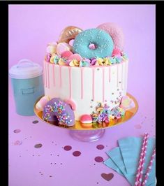 a birthday cake decorated with donuts, sprinkles and confetti