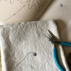 a pair of scissors sitting on top of a piece of paper next to some fabric