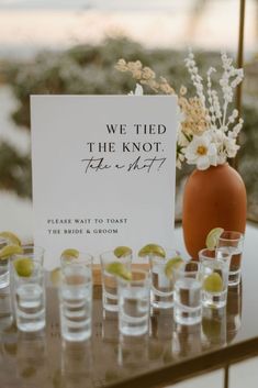 a table topped with shot glasses and a sign that says, we tied the knot