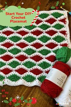 a crocheted afghan with yarn and christmas decorations