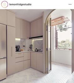 a kitchen with beige cabinets and white flooring next to an open door that leads to a balcony