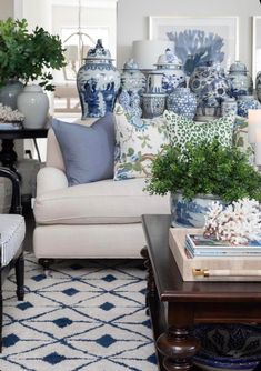 a living room filled with lots of blue and white vases on top of a table