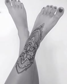 a woman's foot with a tattoo on the top and bottom of her leg