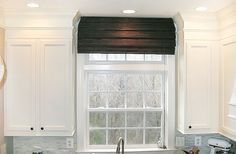 a kitchen with white cabinets and granite counter tops, along with a window over the sink