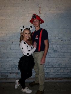 a man and woman dressed up in dalmatian costumes posing for a photo together