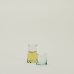 two glasses filled with liquid sitting next to each other