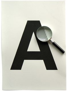 a black and white letter with a magnifying glass on it's side