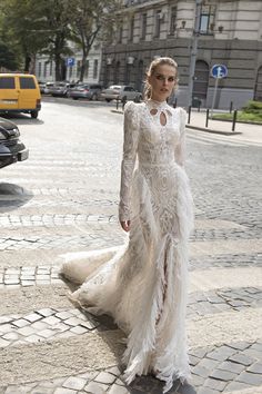 a woman in a white dress is walking down the street