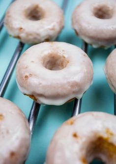 there are many donuts on the rack and one is glazed with white icing