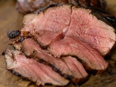 sliced meat sitting on top of a wooden cutting board