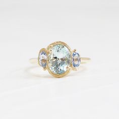 an oval aquamarinee and blue topazte ring with three diamonds on the sides