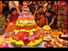 a group of people standing around a table with many different types of flowers on it