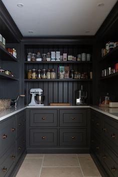 a kitchen with black cabinets and white counter tops