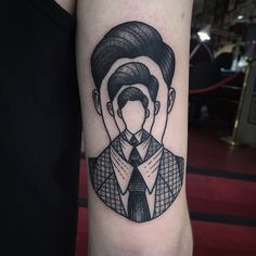 a tattoo on the arm of a man with a tie