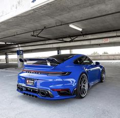 the blue sports car is parked in an empty parking garage with no one around it