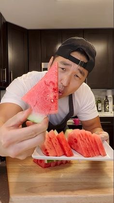 a man eating watermelon slices on a plate