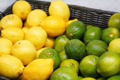 there are many lemons and limes in the basket