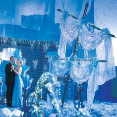 a man and woman standing in front of an ice sculpture