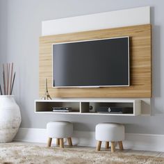 an entertainment center with two stools and a flat screen tv mounted on the wall